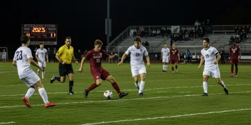 College soccer players competing on a field under stadium lights in 2025, representing new rule changes.