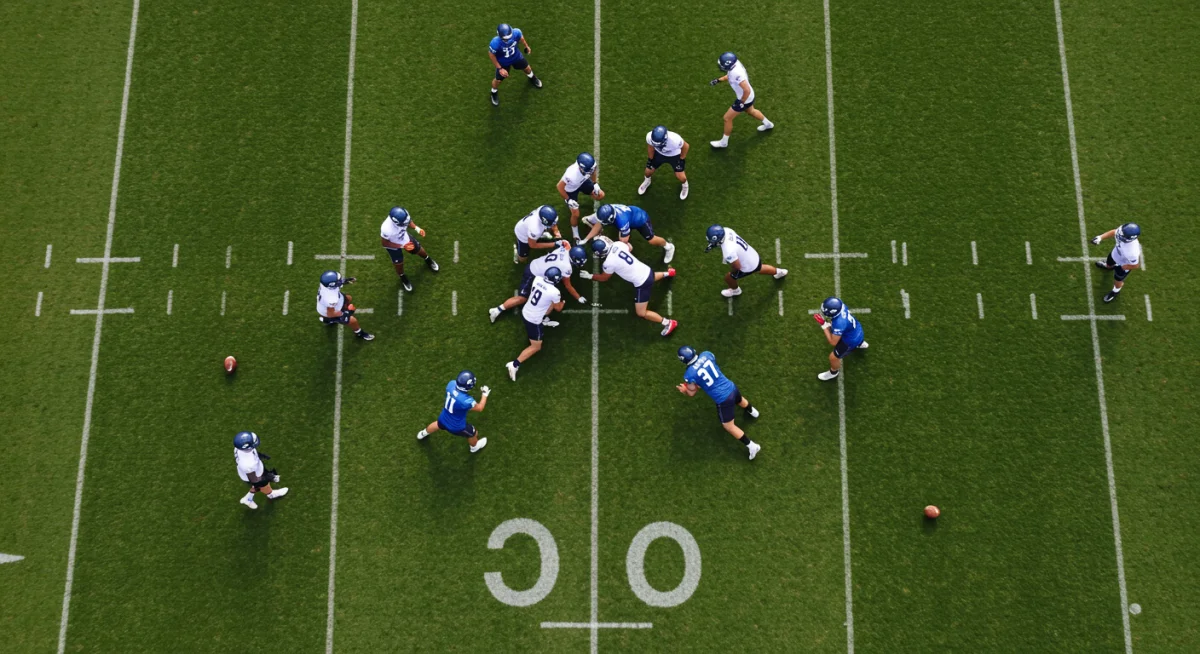 Football team executing a high-press defensive strategy during training, viewed from above.