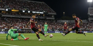 Soccer player scoring a game-winning goal in a vibrant MLS stadium