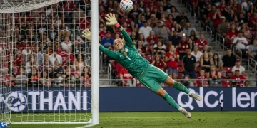 Dynamic image of a NWSL goalkeeper executing a crucial diving save during a high-stakes match.