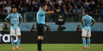 Referee reviewing VAR screen during a controversial MLS match decision.