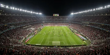 Overview of a bustling Serie A stadium at night, symbolizing financial growth and fan passion