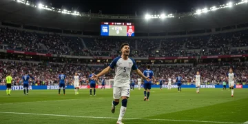 USMNT player celebrating a crucial goal during a 2025 World Cup qualifier, vibrant stadium lights.