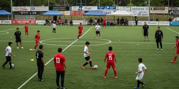 Youth soccer players competing in a large showcase event, observed by college coaches.